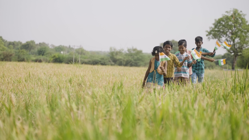 group of playful village kids with Indian flag in hand at paddy agriculture field - concept of independence or republic day celebration, democracy and freedom Royalty-Free Stock Footage #1089956131