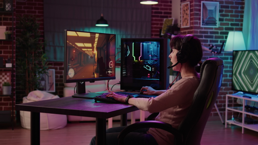 Gamer girl streaming online action game while explaining gameplay to subscribers while sitting in gaming chair. Woman using pc setup playing multiplayer first person shooter talking on headset. Royalty-Free Stock Footage #1089956465