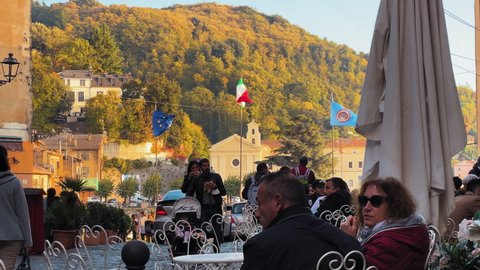 Nemi , Italy - 10 21 2021: Slow motion shot of tourist sitting outdoors in cafe in Nemi City during sunny day - Static shot