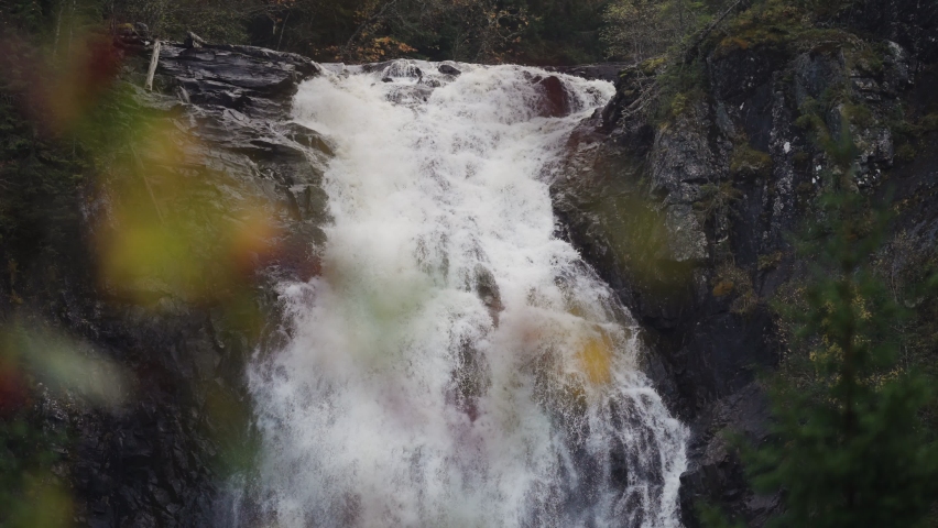 A famous Storfossen waterfall in Norway. A powerful stream of water falls from the black rocks. Slow-motion, long exposure.