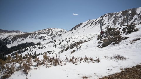 Ski lift taking skiers and snowboarders to the top of the mountains during the spring
