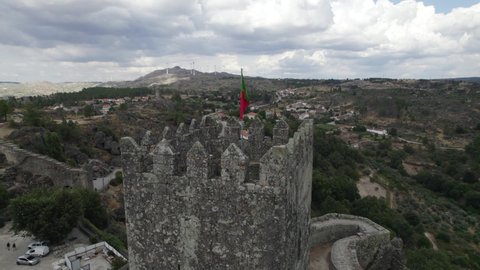 Portuguese Flag at Hilltop towering castle of Sortelha, Portugal. Orbiting shot