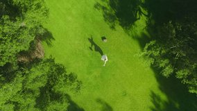 4K aerial footage energetic woman in white dress looking up in drone camera and taking off white hat on summer day. Happy young cheerful girl spinning around outdoors on green lawn Video series 1 of 6 - Powered by Shutterstock - Get 15% off with code: PIKWIZARD15