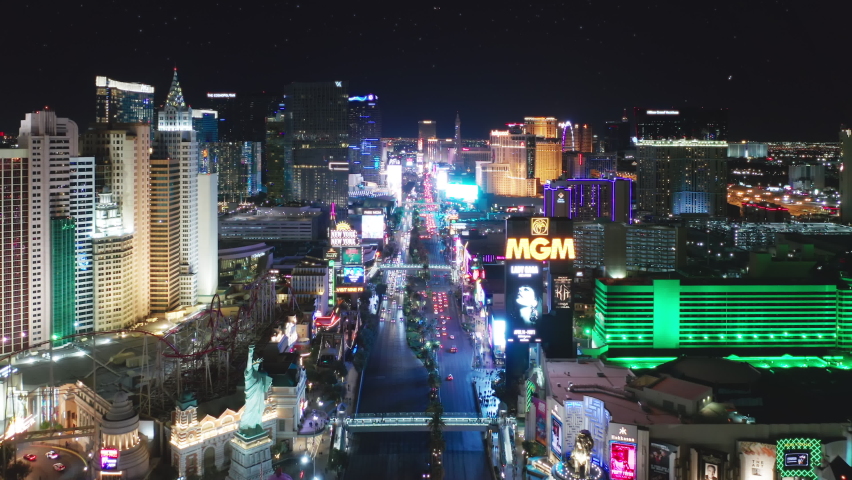Las Vegas Strip Nevada Apr. 2022. Epic aerial above busy night traffic drone flying between illuminated hotels on Strip New York, MGM Grand. Entertainment gambling capital, holidays travel concept 4K