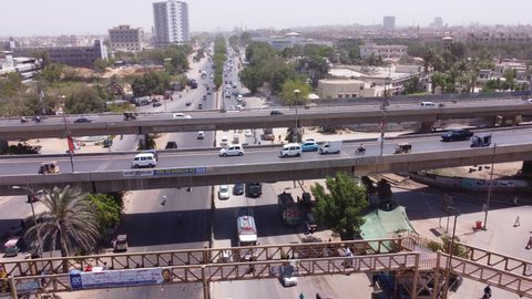 Fast flowing traffic in Karachi, bridges can also be seen. Graffiti ads in Urdu Translation "Karachi should be given its due share"