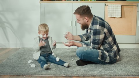 Father and Son Playing on Floor with Shaving Foam. Boys Sitting on the Floor and Fool at Home. Enjoying of Each Other at Domestic Life. Handsome Father and Son Spend Quality Family Time Together