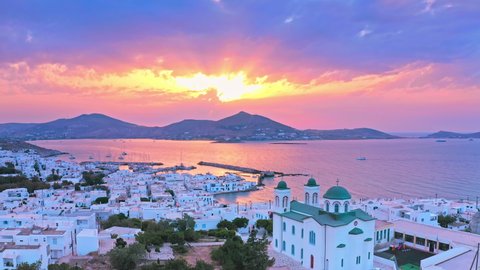 Greek island Paros sunset aerial view. Sun rays through sky clouds and calm sea