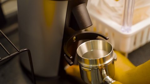 Close of a man grinding coffee bean using a single dose grinder machine