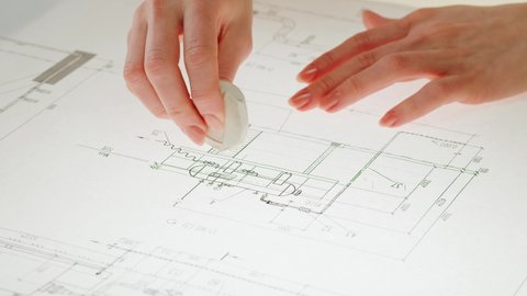 Architect designer drawing plan blueprint close-up, using eraser. Professional engineer working, interior creator making architectural house project, drafting building.