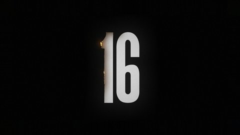 The number 16 burns and turns into ashes on a black background