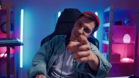 Young hipster man playing online computer video game, colorful lighting broadcast streaming live home. Ecstatic celebration winning match. Gamer lifestyle, E-Sport online gaming technology concept - Powered by Shutterstock - Get 15% off with code: PIKWIZARD15