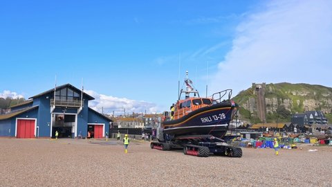 Hastings, East Sussex, UK, April 13, 2022. The RNLI Shannon Class Lifeboat towed by the launch and recovery system towards the Lifeboat station at Hastings while volunteers prepare to hose her down.