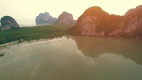 Aerial view over the coast, mountains and beaches during beautiful sunsets. Paradise island of “Underwater Wedding Beach” Trang, Thailand. 4k drone footage
