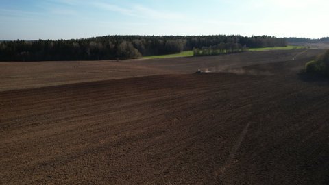 Tractor plowing field, drone view. Cultivated land and soil tillage. Tractor with disc cultivator on cultivating. Agricultural tractor on field cultivation. Tractor disk harrow on plowing field. 