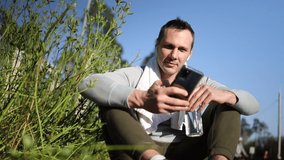 young caucasian man sitting on bench outdoors in summer checking his smartphone relaxing with water bottle after workout
 - Powered by Shutterstock - Get 15% off with code: PIKWIZARD15