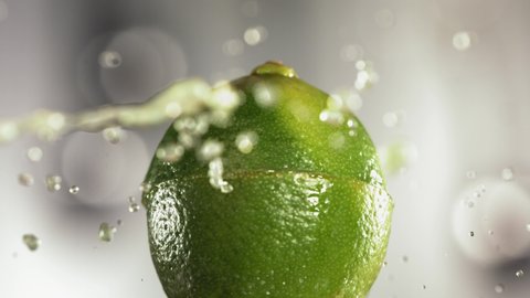 Half Lime falling and splashing on white background. Food levitation concept. Slow Motion