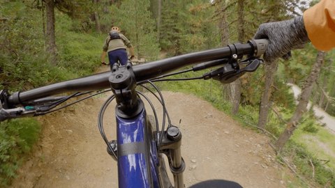 Mountain bike point of view. Rider descends technical trailing the forest.