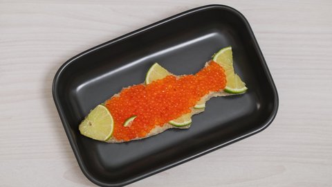 Sandwiches with salmon caviar salted roe in plate chef put on table. Sandwich with red caviar in shape of fish with lemon. Expensive healthy food concept close-up slow motion. Fish dish. Sea food