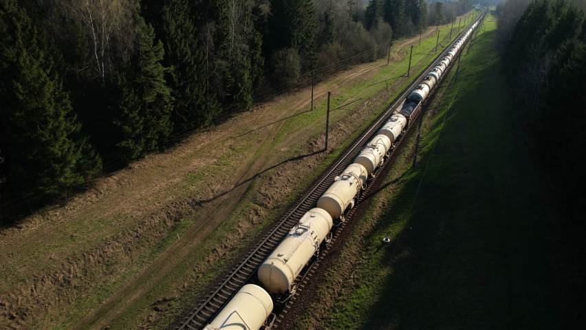 Freight Cars Deliver bulk Materials and gravel. Open Hoppers on railroad. Freight train with petroleum tank cars. Rail cars carry oil, crude and gas, ethanol. Railway logistics explosive cargo.  Royalty-Free Stock Footage #1089983291