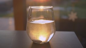 SLOW MOTION, CLOSE UP: Effervescent tablet dissolving in sunlit glass of water. Sparkling beverage for regaining health backlit with beautiful golden light. Seasonal home treatment for immunity boost. - Powered by Shutterstock - Get 15% off with code: PIKWIZARD15