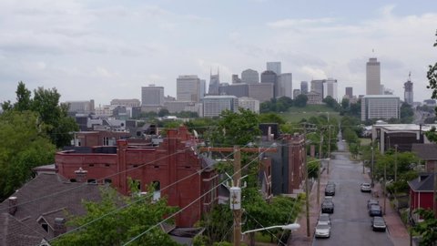 Nashville, Tennessee, USA - May 6 2022: Dolly move forward from Germantown neighborhood to Capitol Hill and  Nashville skyline in the background. Drone, aerial shot. Cloudy day.