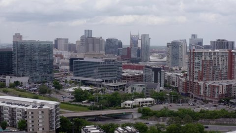 Nashville, Tennessee, USA - May 6 2022: Pan left to right of downtown Nashville skyline. Shot from The Gulch. Cloudy day.