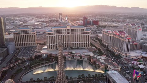 Twilight high angle view of Strip cityscape with cinematic rose pink sunset view. Scenic Bellagio fountains show illuminated in dusk under pink sky over horizon. Las Vegas Strip Nevada, USA April 2022