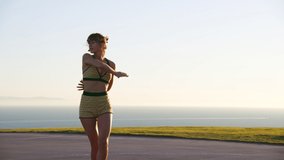 Cheerful female athlete riding on roller skates on a windy summer day by the picturesque ocean. Happy woman dances on rollers, enjoying summer outdoor sports. High quality 4k footage