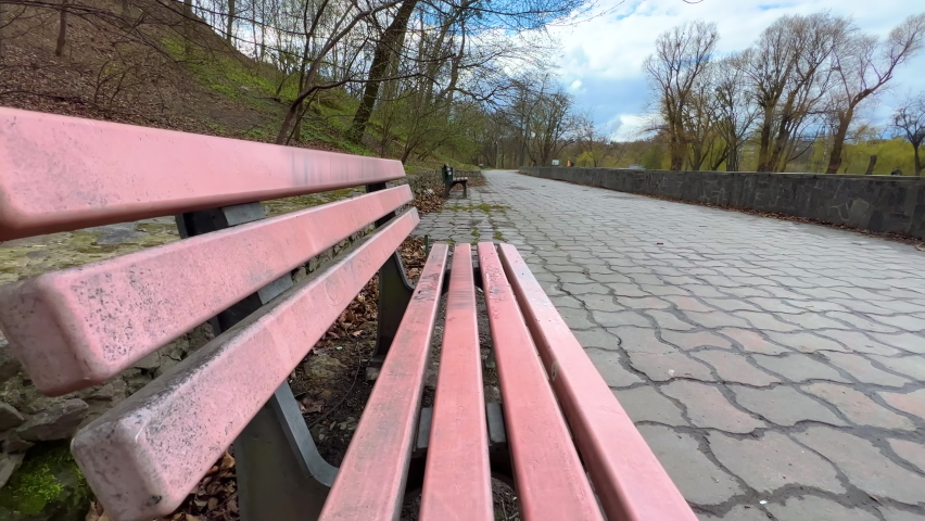 Empty bench in the park on a cloudy day in early spring