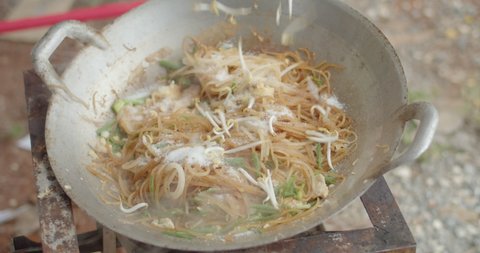 How to make Pad Thai: Add bean sprouts and mix them with vegetables, pork and noodles.