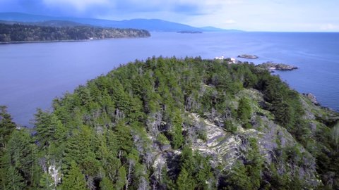 Flying over Merry Island Forest rotating to reveal mainland Sunshine Coast British Columbia