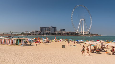 Dubai, United Arab Emirates - October 23 2021: People on Marina Bay Mall with the Ferris wheel Ain Dubai in the background