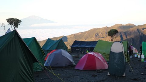Kilimanjaro. Tanzania. Africa - 12.25.2021: Shira camp in the morning, tourists gather for climbing, porters gather equipment. Many tents on the background of Mount Kibo