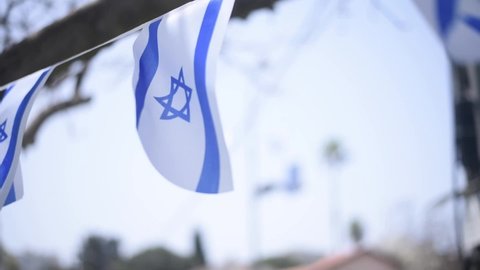 Israel flags white and blue with star Magen David fluttering in wind. many flags prepare to Independence Day of Israel. outdoor. big holiday