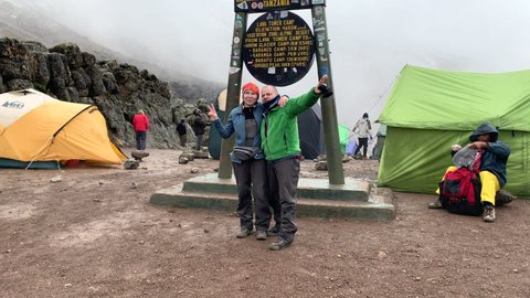 Kilimanjaro. Tanzania. Africa - 12.25.2021 Tourists are photographed near the Stella in the Lava Tower camp during fog and drizzling rain
