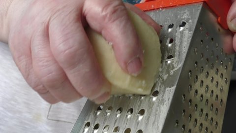 the cook rubs the cheese on a grater. healthy food concept