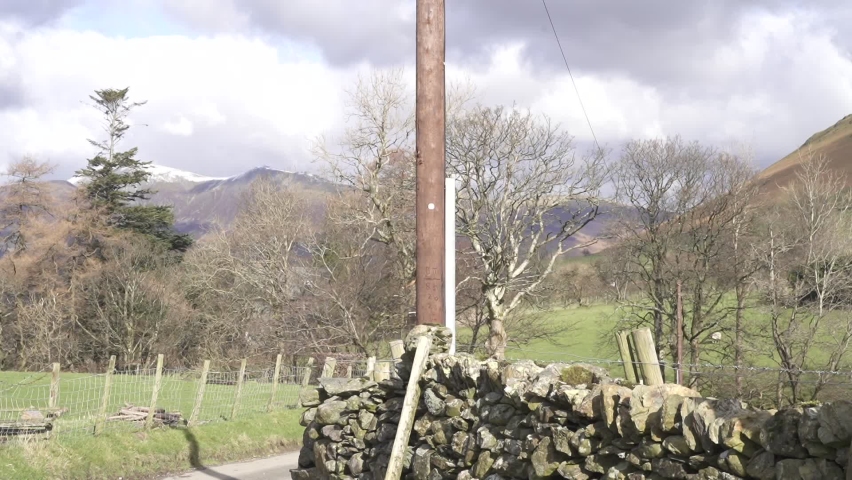 A Shot fo the road moving up to frame a crossroads signpost depicting the nearest mountains to climb or hike trekking into the hills 