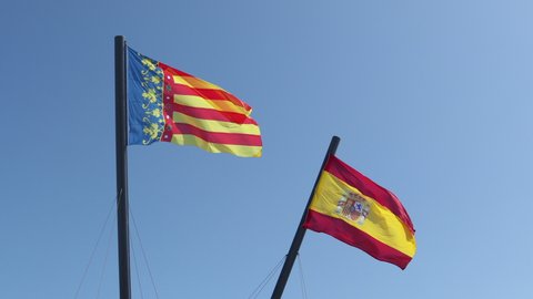 Flags of the city of Valencia Spain and the country Spain, waving together on a flagpole in 4k resolution.