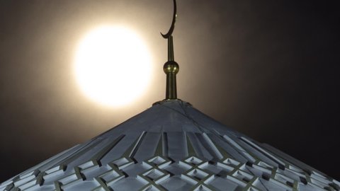 Illuminated Dome of The Hazrat Sultan Mosque in Astana timelapse at night with full moon passing through crescent, Nur-Sultan city, Kazakhstan