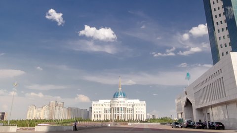 House of Parliament of the Republic of Kazakhstan and modern orange tower timelapse hyperlapse, Astana. Government district. Ak Orda on background. Blue cloudy sky at summer day. Nur-Sultan city