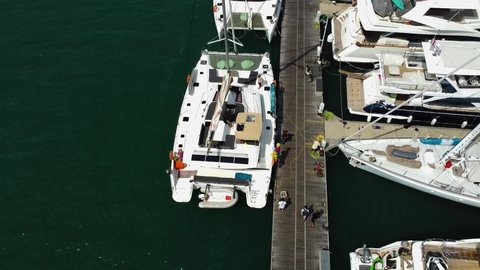 Phuket, Thailand, 24, February,2022:
The sailboat is in the yacht marina, the charter company team is preparing the sailing catamaran for departure
