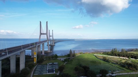 Lisboa, Portugal, April 24, 2022: DRONE PAN FOOTAGE - The Vasco da Gama Bridge and the Vasco da Gama Tower at Park of Nations in Lisbon. Modern residential neighborhood with contemporary architecture.