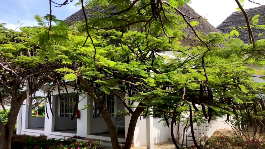 Typical house in the coast of Watamu beach in Kenya. Holiday house with garden by the sea. White beach, palm trees and lush vegetation.