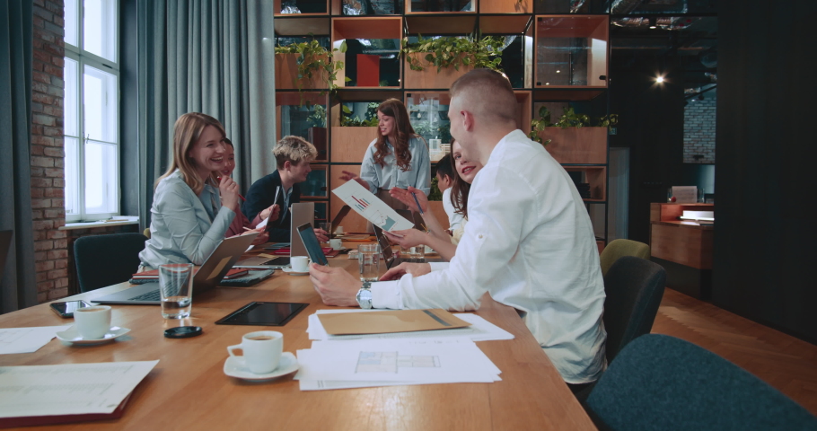BUSINESS MEETING Group of happy excited colleagues brainstorming, working together at trendy office workplace table.