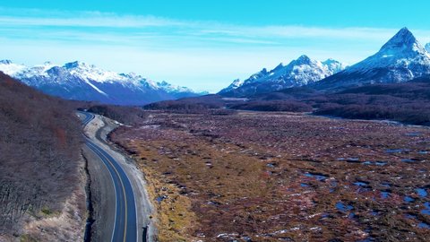 Patagonia road at Ushuaia Argentina province of Tierra del Fuego. Stunning road between nevada mountains and colorful forest trees. Ushuaia Argentina. Patagonia Argentina at Ushuaia Argentina.