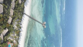 Vertical video house on stilts in the ocean on the coast of Zanzibar, Tanzania, aerial view