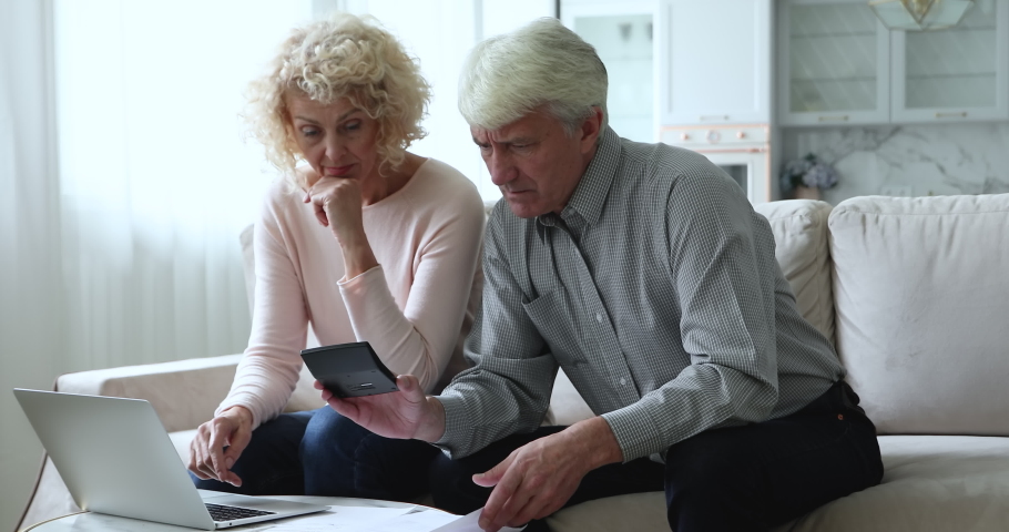 Retired couple calculate bills at home, manage family budget feeling upset due lack of money, high taxes and utilities, experiencing financial difficulties. Bankruptcy, bank debt, overspend concept Royalty-Free Stock Footage #1090023253