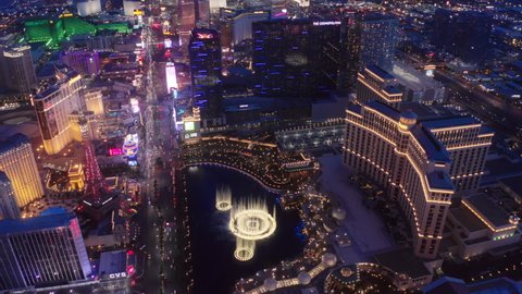 Resort Casinos on Las Vegas Strip, USA Apr 2022. Aerial 4K high angle view of Strip cityscape with cinematic bright colorful night city lights view. Scenic Bellagio fountains show illuminated at night
