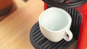 4k video, Automatic coffee machine with black coffee capsules or coffee pods pouring espresso drink in ceramic white cup with hot smoke. Breakfast time with Making Fresh Americano drink.