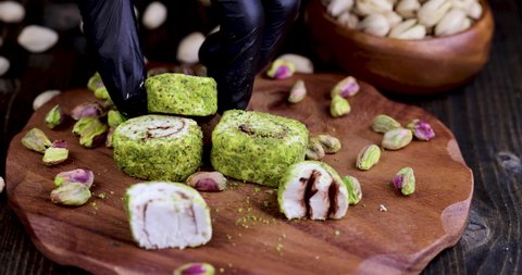 fresh Turkish delight with crushed pistachios and chocolate, pick up fresh Turkish delight from a wooden board